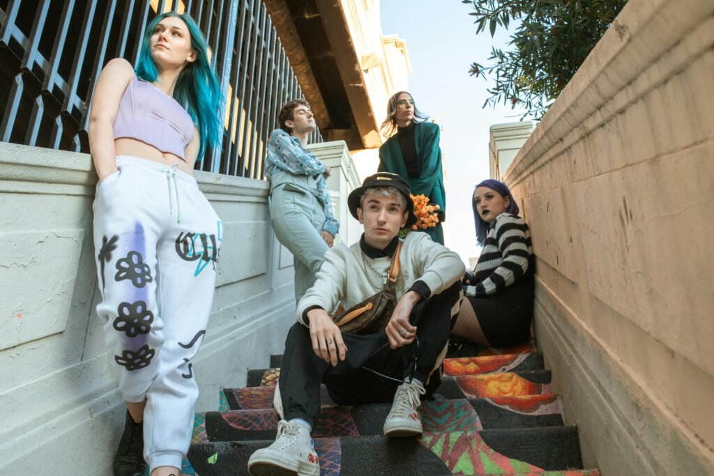 Group of young adults showcasing diverse street fashion on urban stairs.